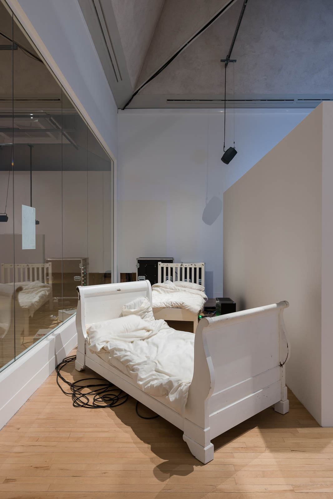 Ed Atkins, Beds, 2025, motor, battery, wooden bed frame, cotton sheets, installation view Tate Britain
